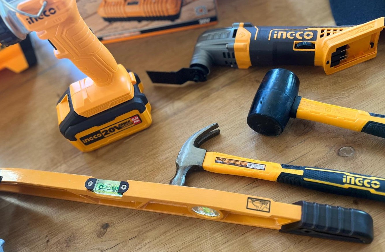 Ingco spirit level, hammer and mallet on a wooden table